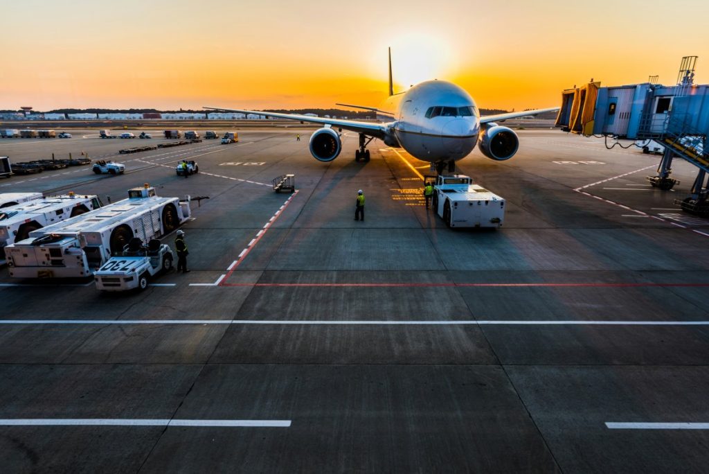 An aeroplane at an airport at sunrise.