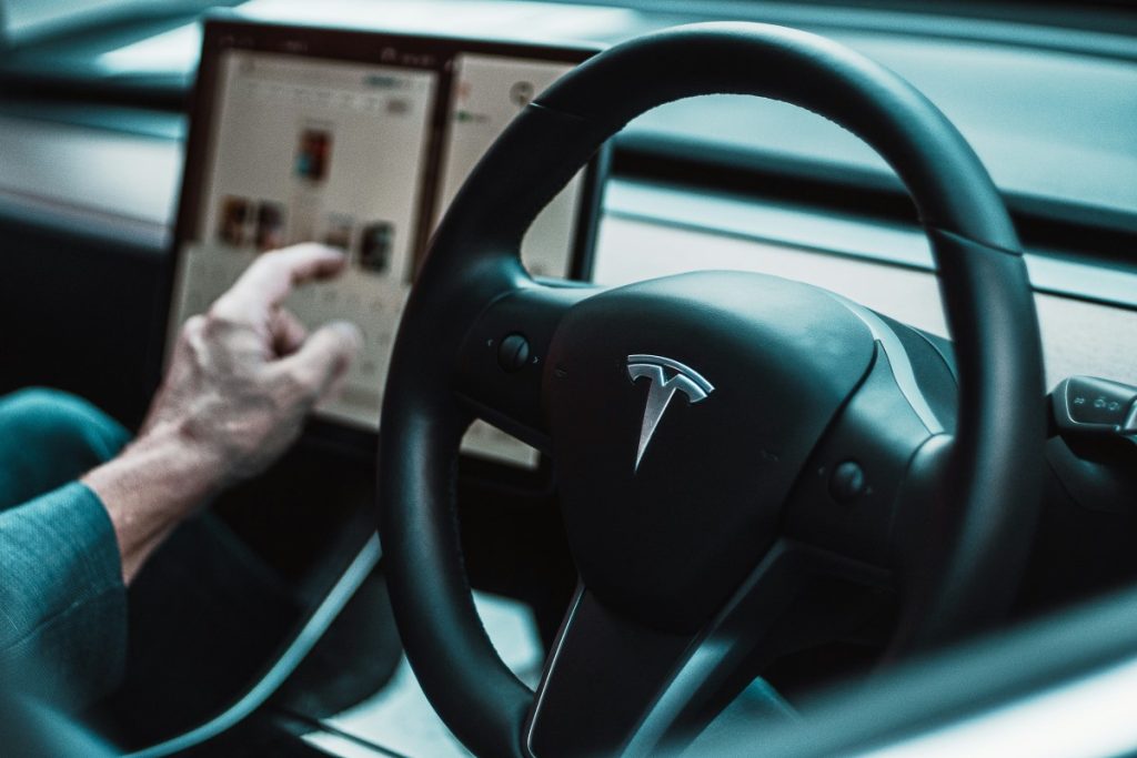 A driver uses the touch screen interface in a Tesla vehicle.